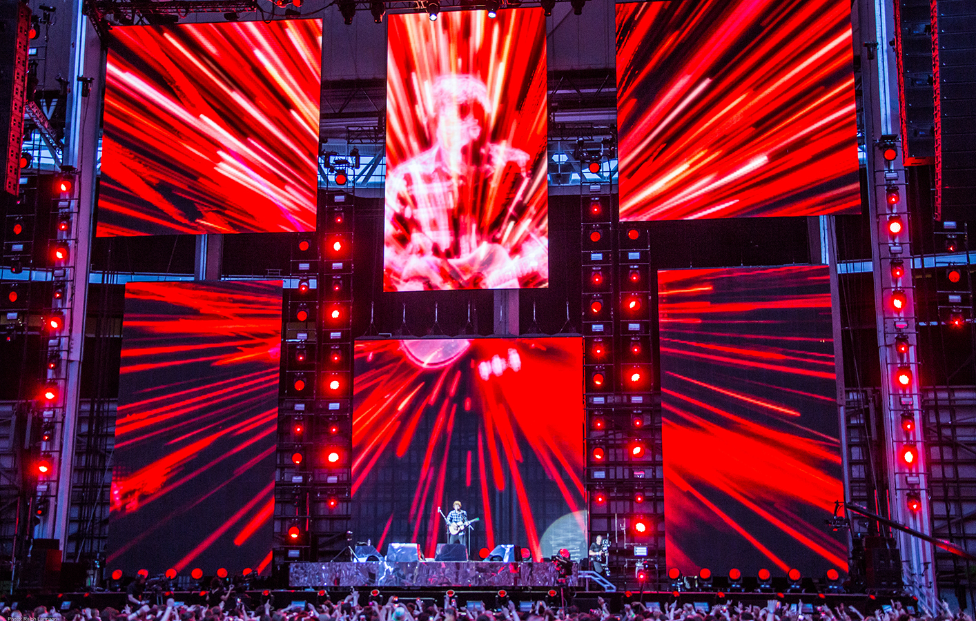 Ed Sheeran displayed across multiple LED screens with red lights sprawling across screens
