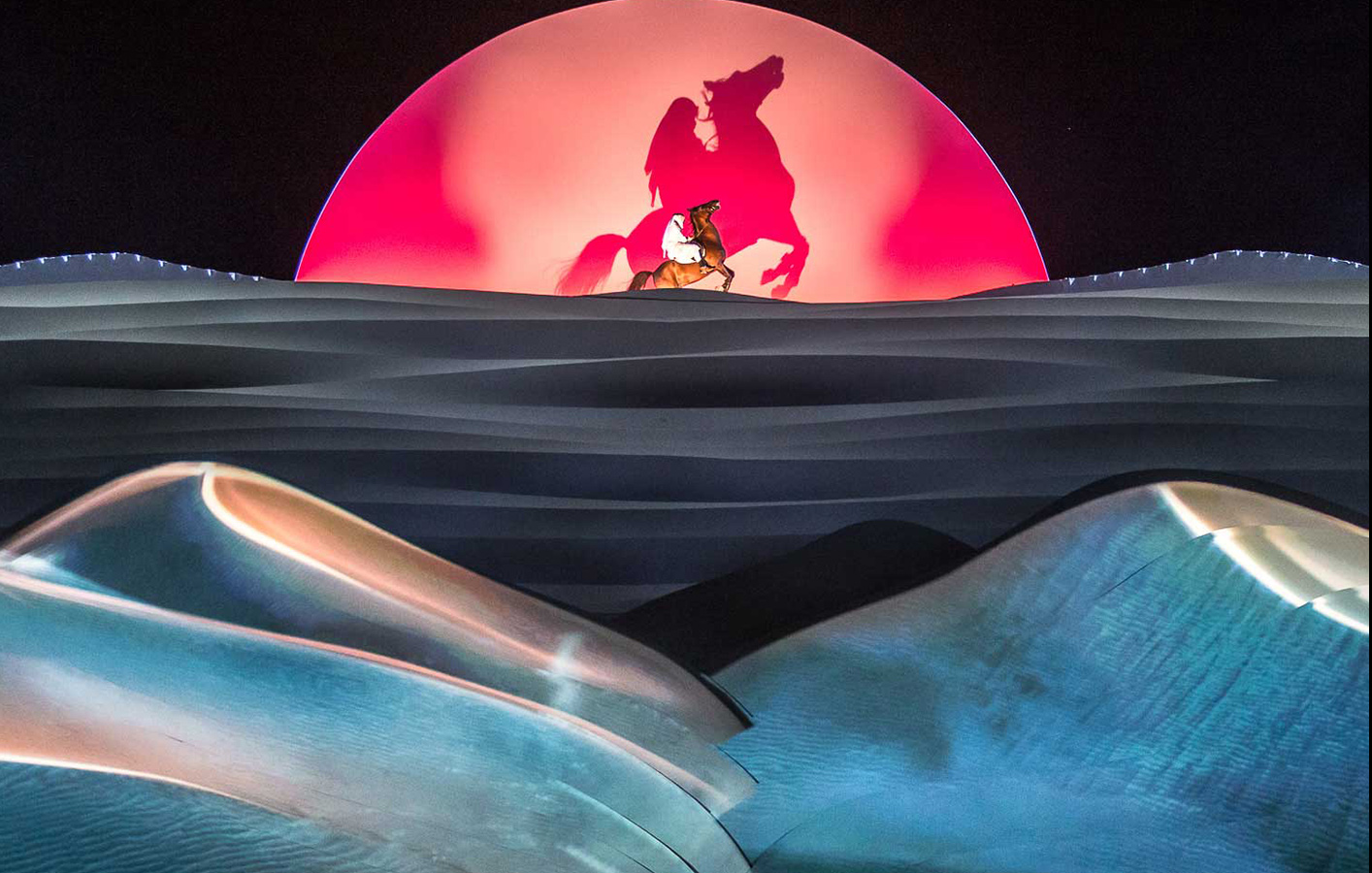 Man riding a horse in front of red moon