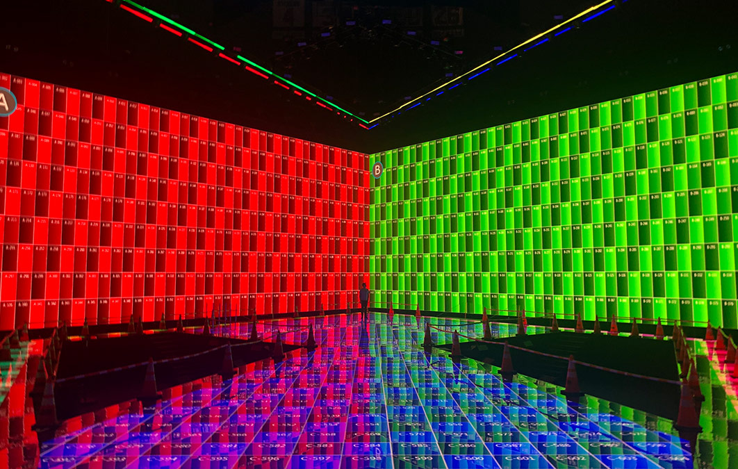 Man standing on empty stage with plain red and green displays on LED screens