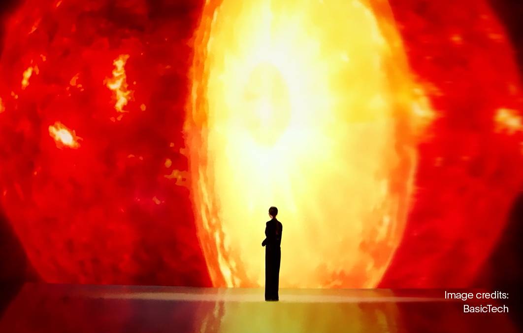 Woman stands in front of bright red light across large LED screen