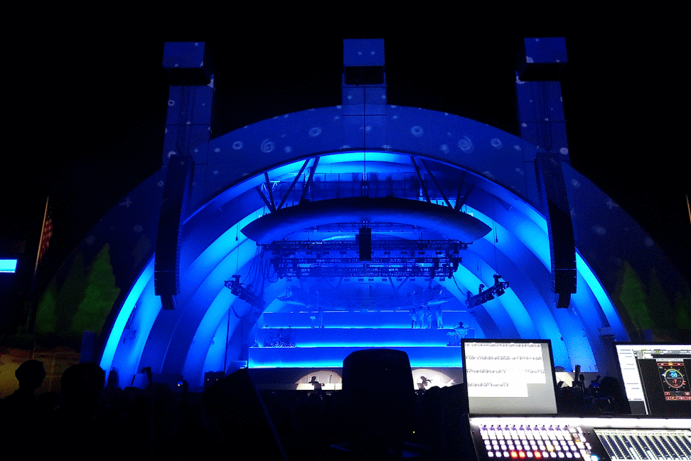Stage lit with blue lighting seen from sound desk
