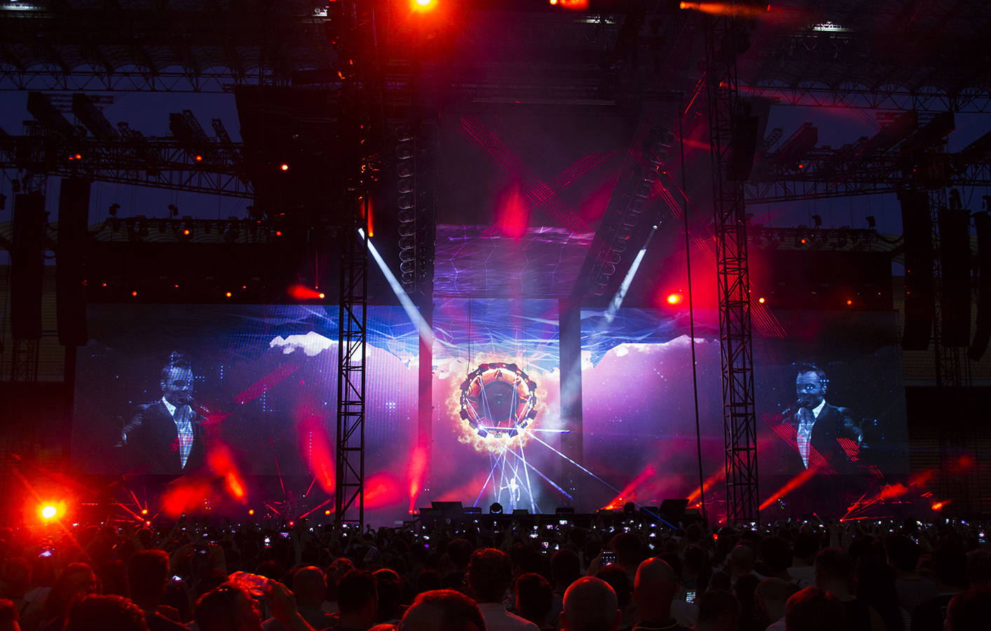 crowd watches Tiziano Ferro performance as LED screens where the visual display of wheel on fire