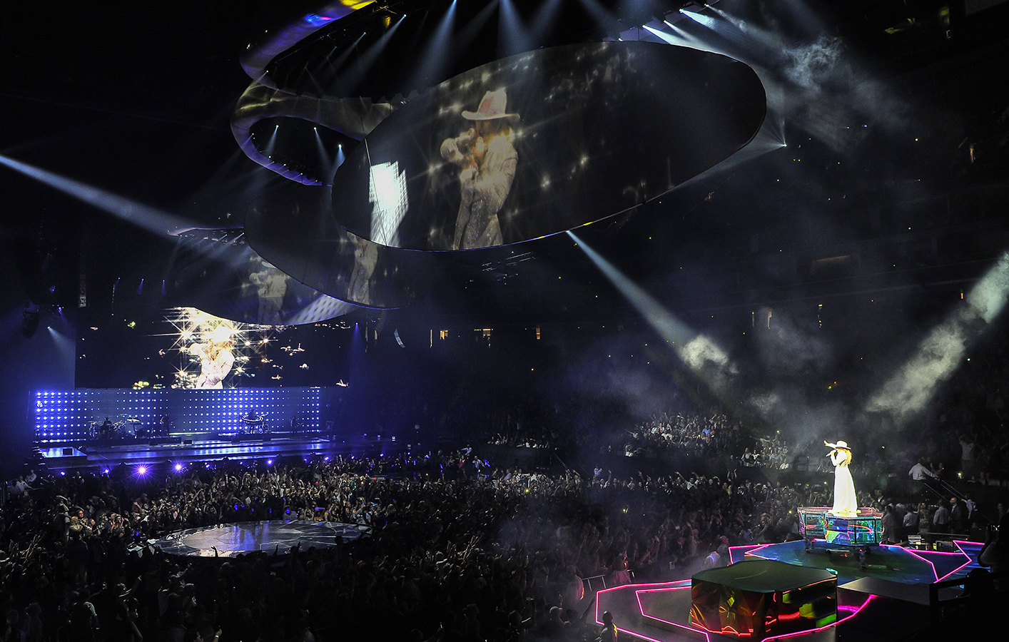Crowd watching lady gaga live on stage with multiple screens projecting her image