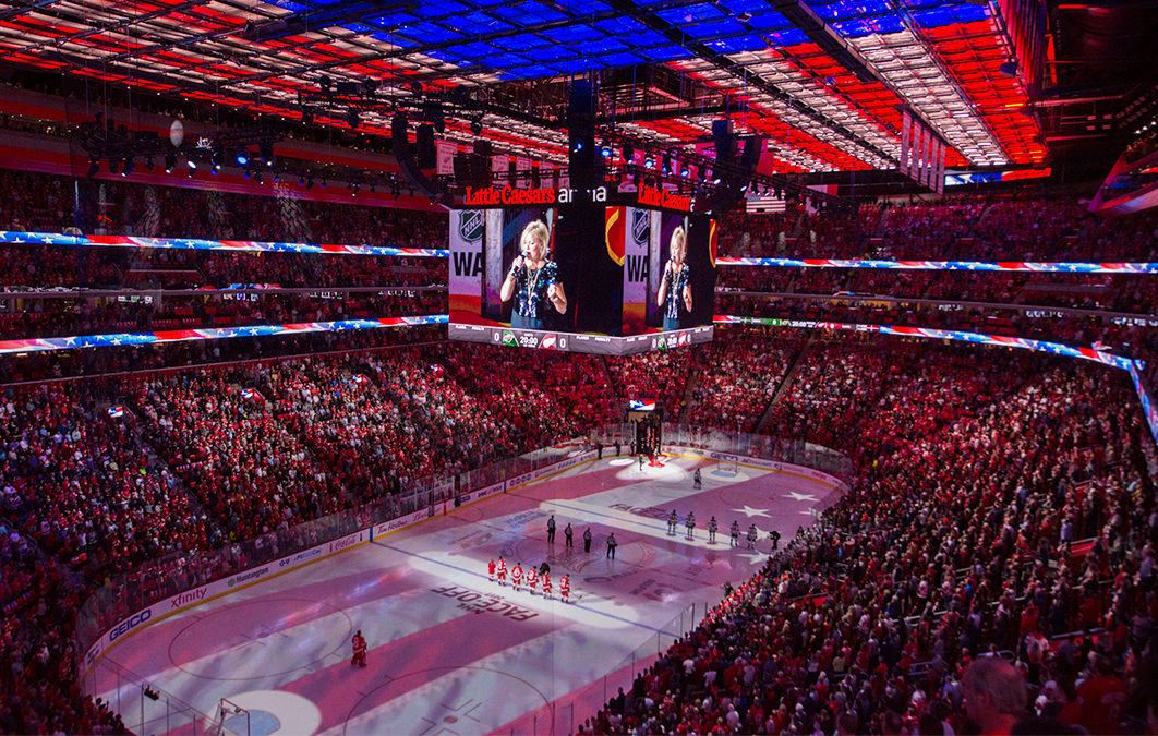 Crowd watching woman sing national anthem at Little Caesars arena