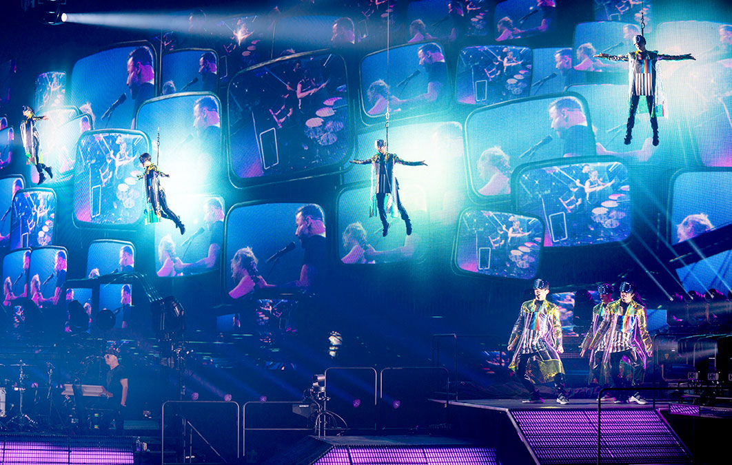 complex stage design featuring multiple dancers and screens