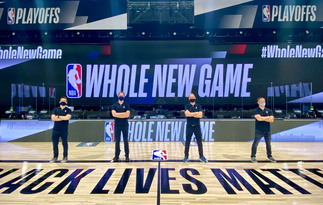 Four people in mask standing on NBA court