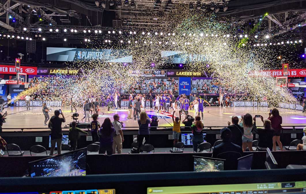 People celebrating as basket ball players play on court