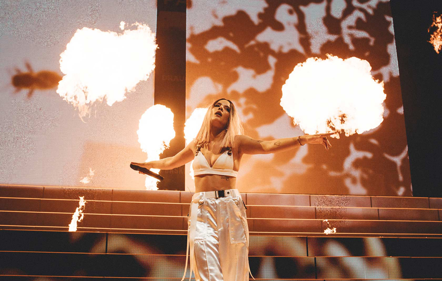 Halsey on live stage surrounded by jets of fire