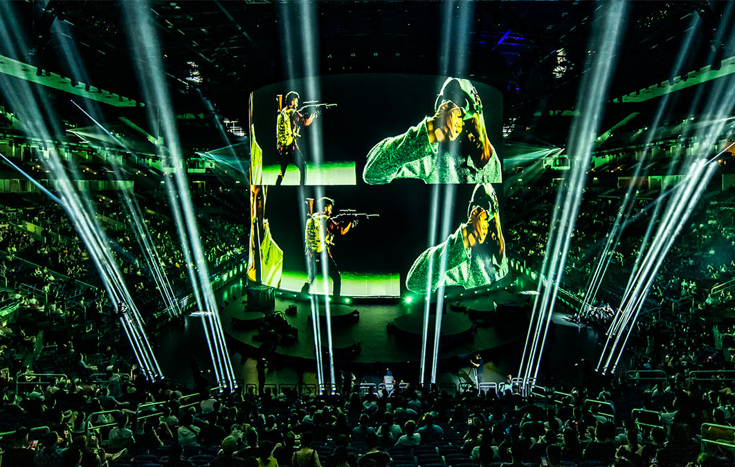 large curved screens show video featuring soldiers and performers