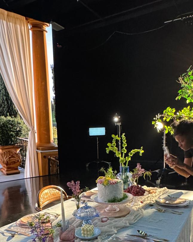 A person taking a photo of a table set up in front of an LED Volume