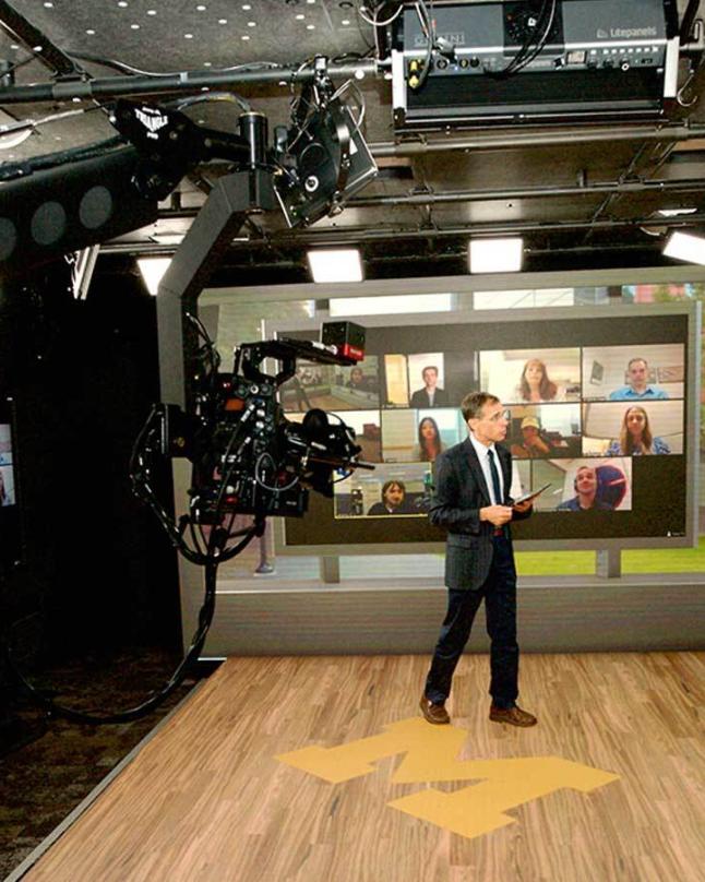 A professor teaching students from a virtual production stage