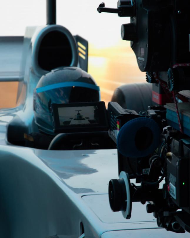 Camera shooting person sitting in f1 car