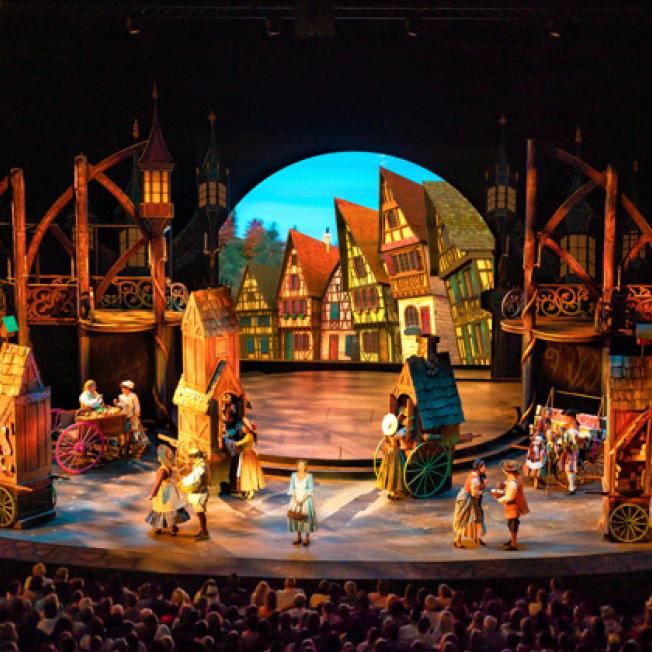 Actress playing Belle performing in village scene