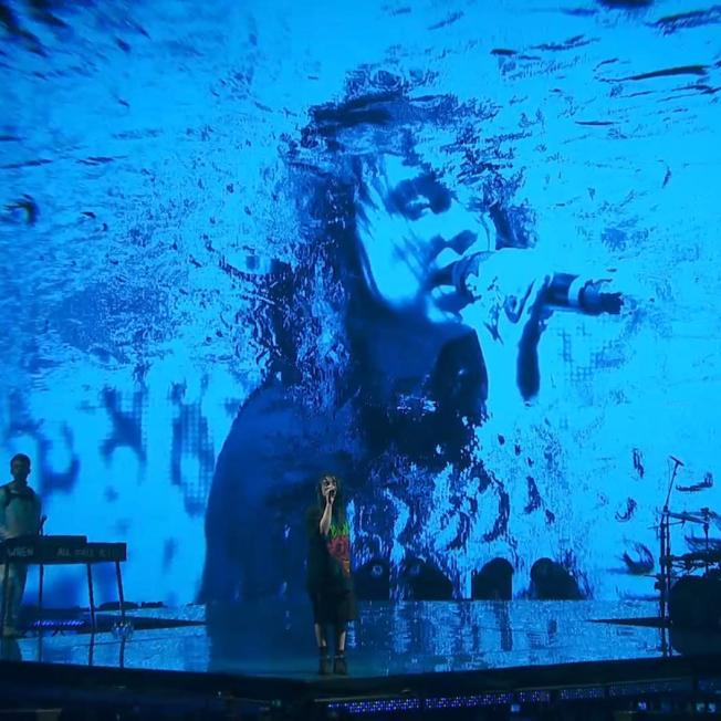 Billie Eilish's face is displayed on LED screens with multiple effects