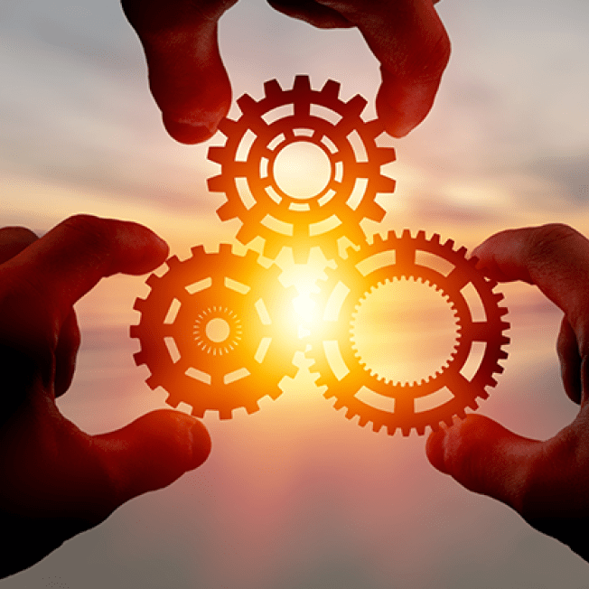 three hands holding cogs
