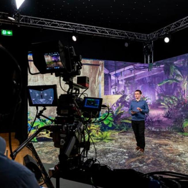 presenter speaks to camera on LED stage with distopian virtual setting