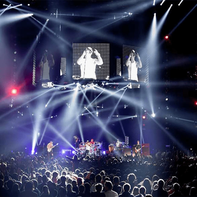 Red hot chilli peppers playing live on stage with multiple screens showing lead singer