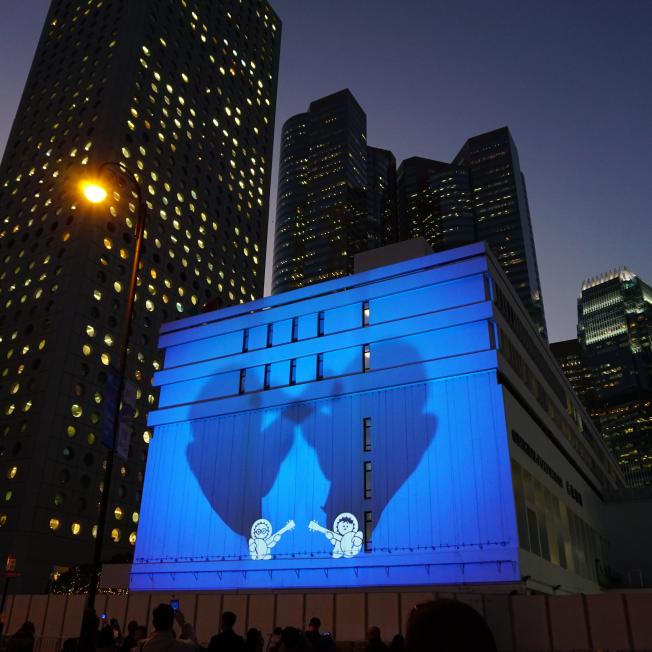 two cartoon characters projected on building in hong kong