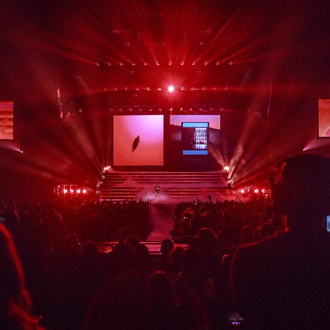 Halsey playing live on stage lit in red lighting