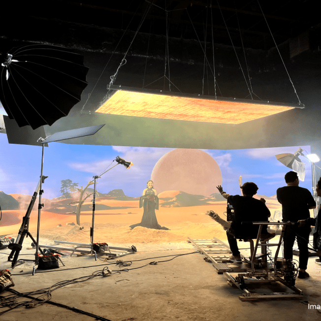 Virtual production stage of team shooting woman standing in desert
