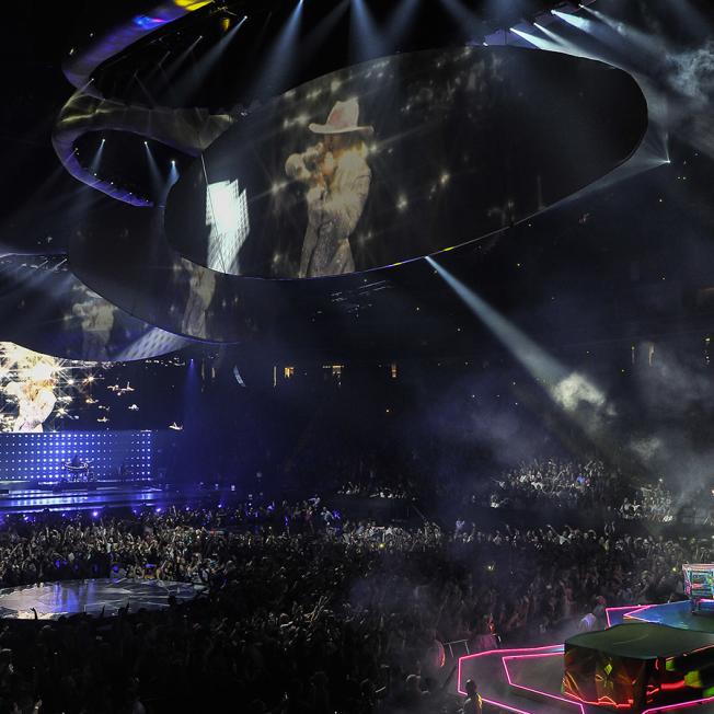 Crowd watching lady gaga live on stage with multiple screens projecting her image