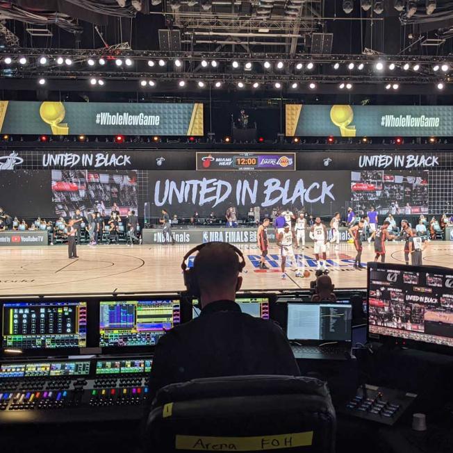 Backstage of man working on visual displays for basketball game