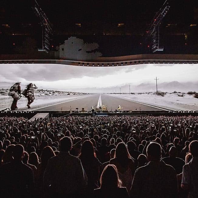 Crowd watching u2 play in front of large LED Display