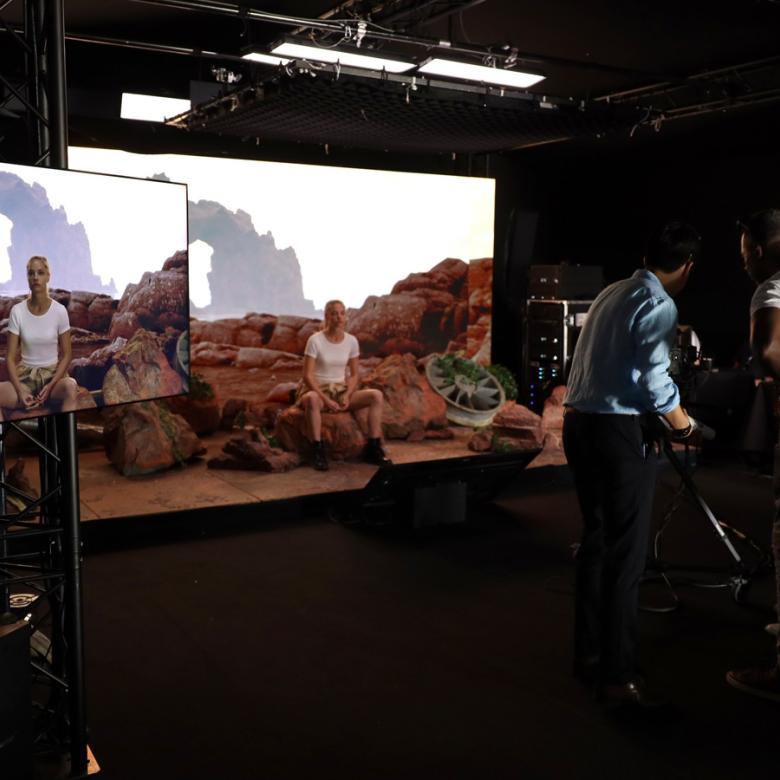 two men filming a women on a virtual production stage. 