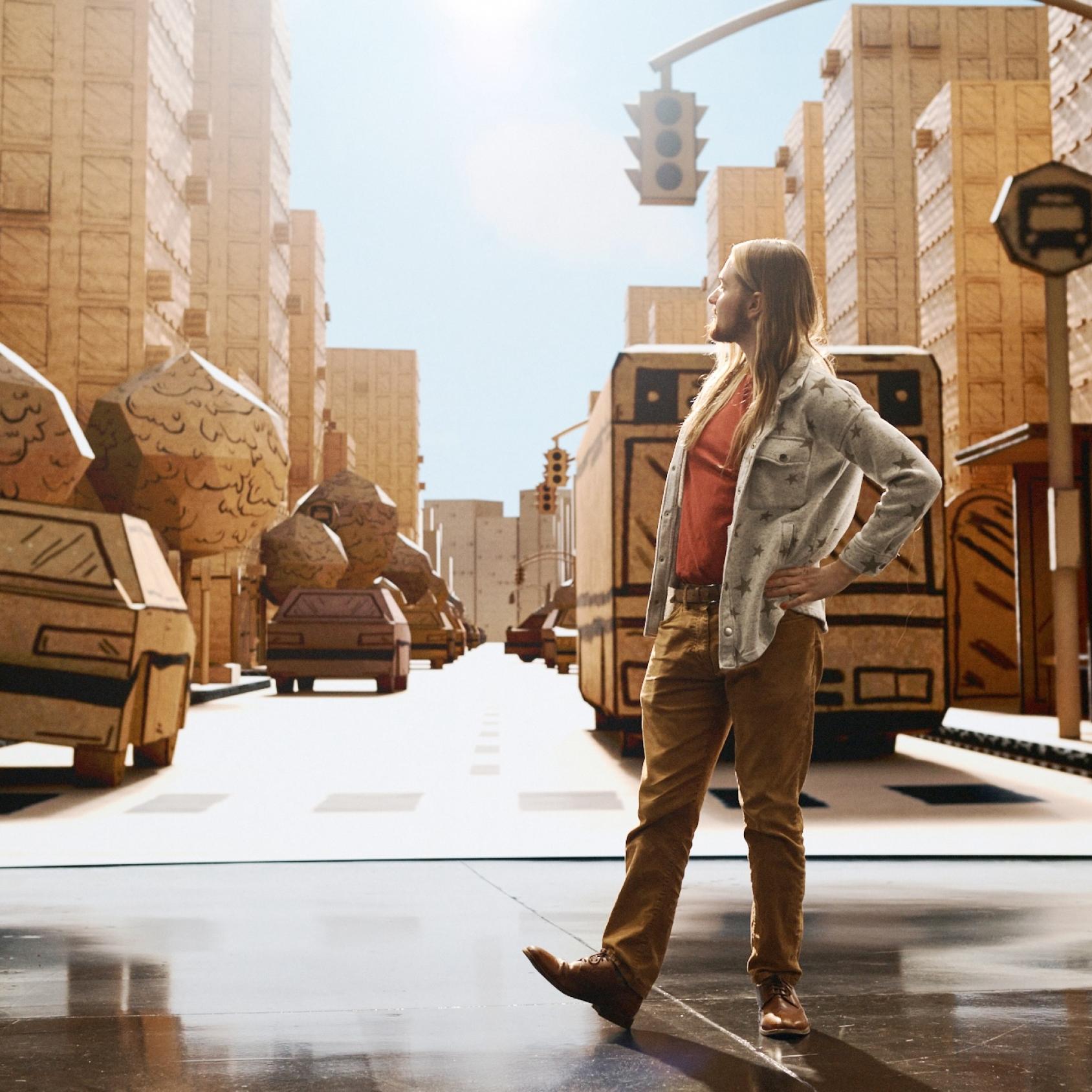 A person standing in front of an LED Volume displaying a cardboard city