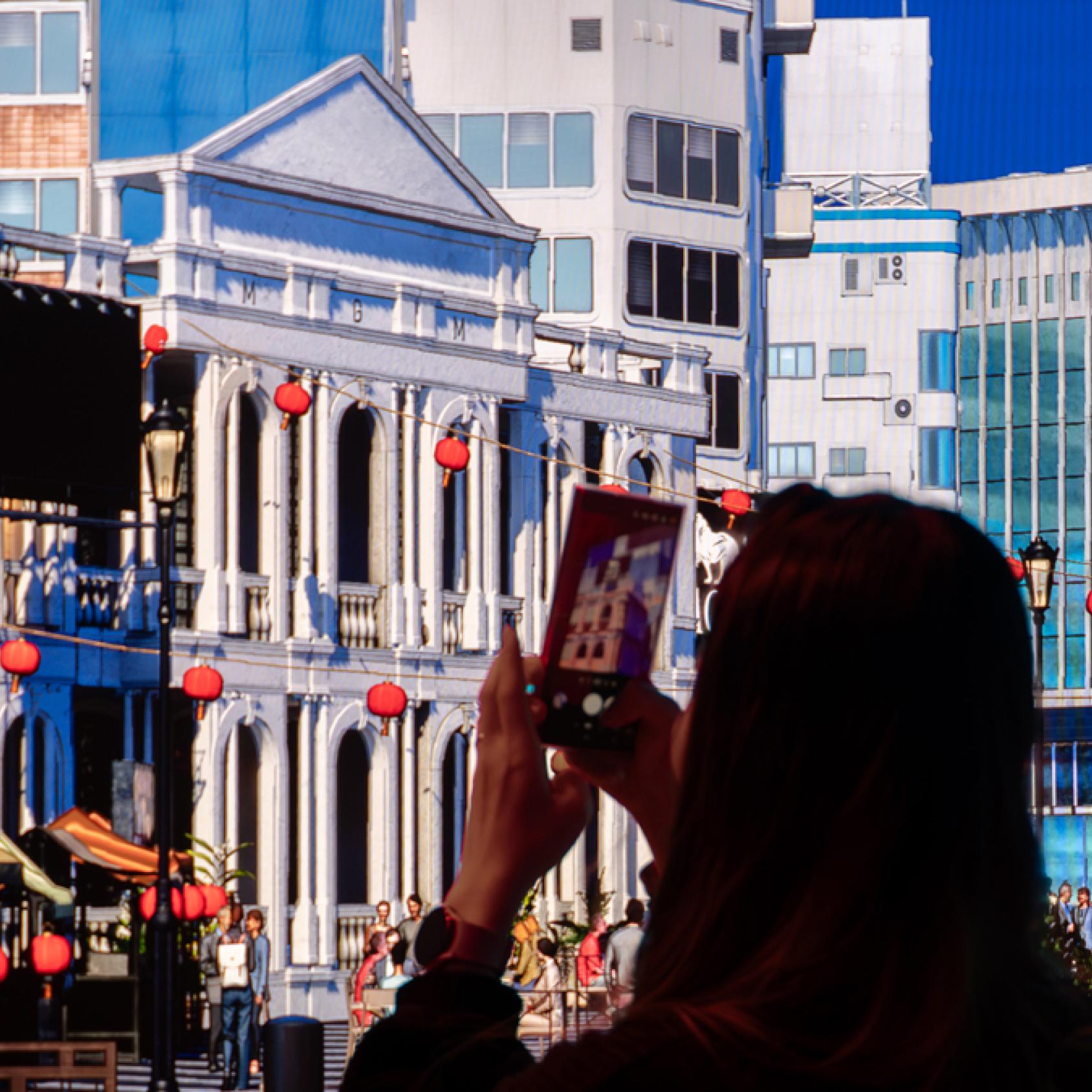 A person taking a photo of a virtual environment on their phone 