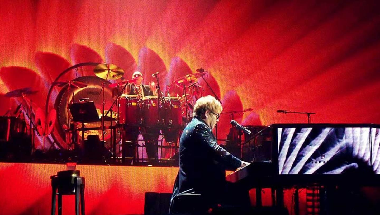 Elton John playing piano on stage