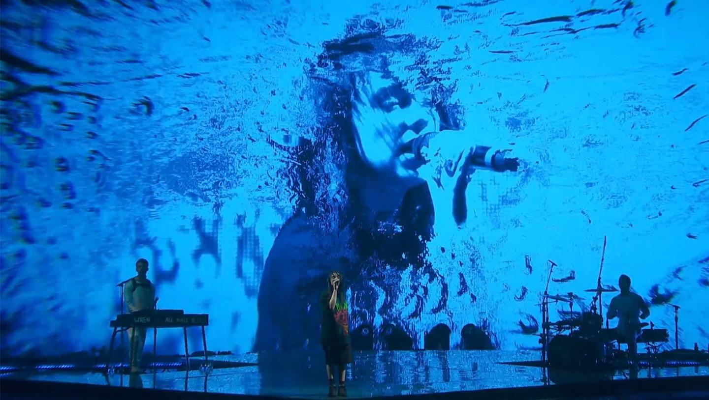 Billie Eilish's face is displayed on LED screens with multiple effects