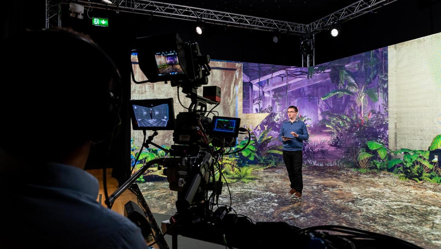 presenter speaks to camera on LED stage with distopian virtual setting