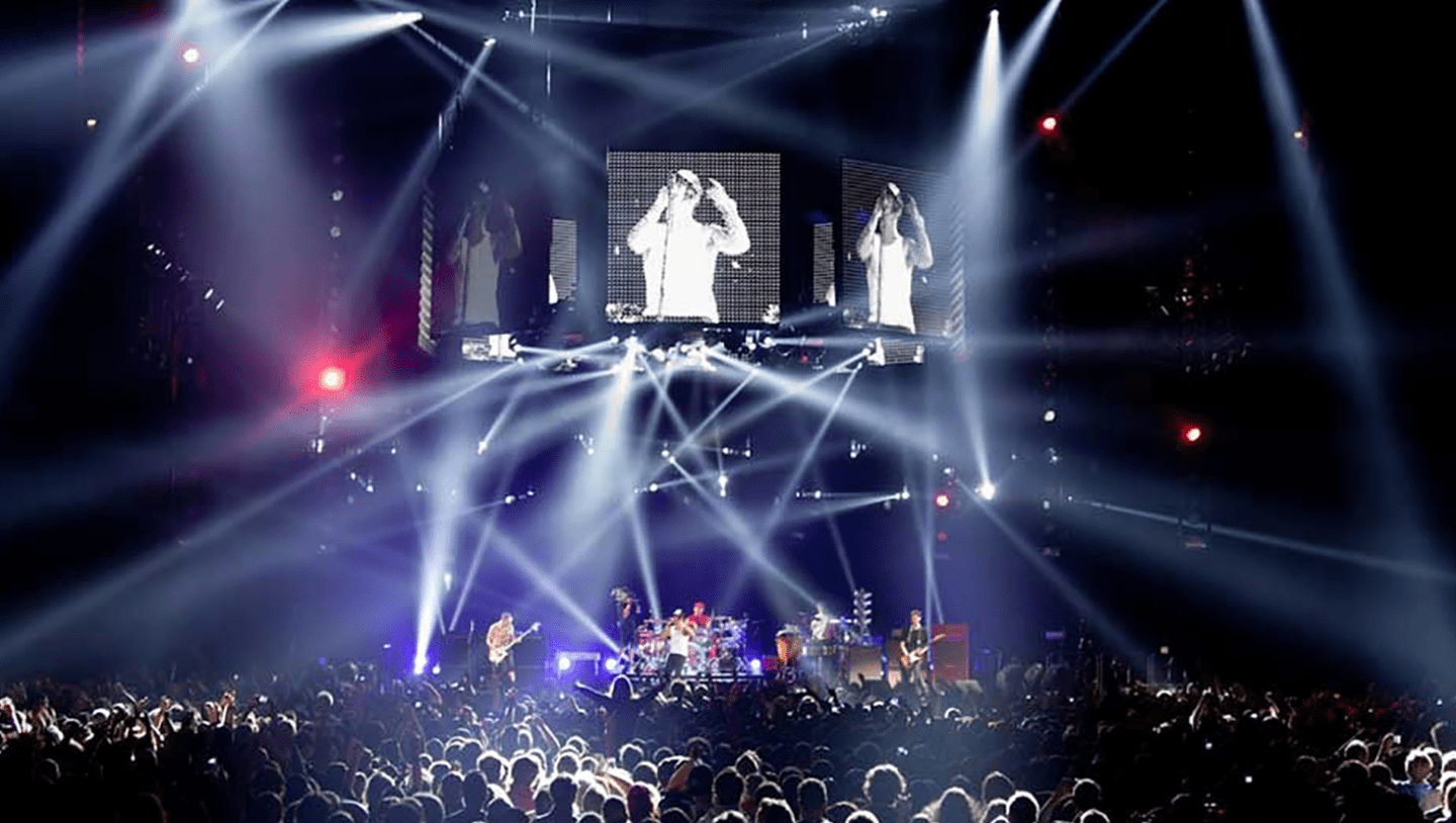 Red hot chilli peppers playing live on stage with multiple screens showing lead singer