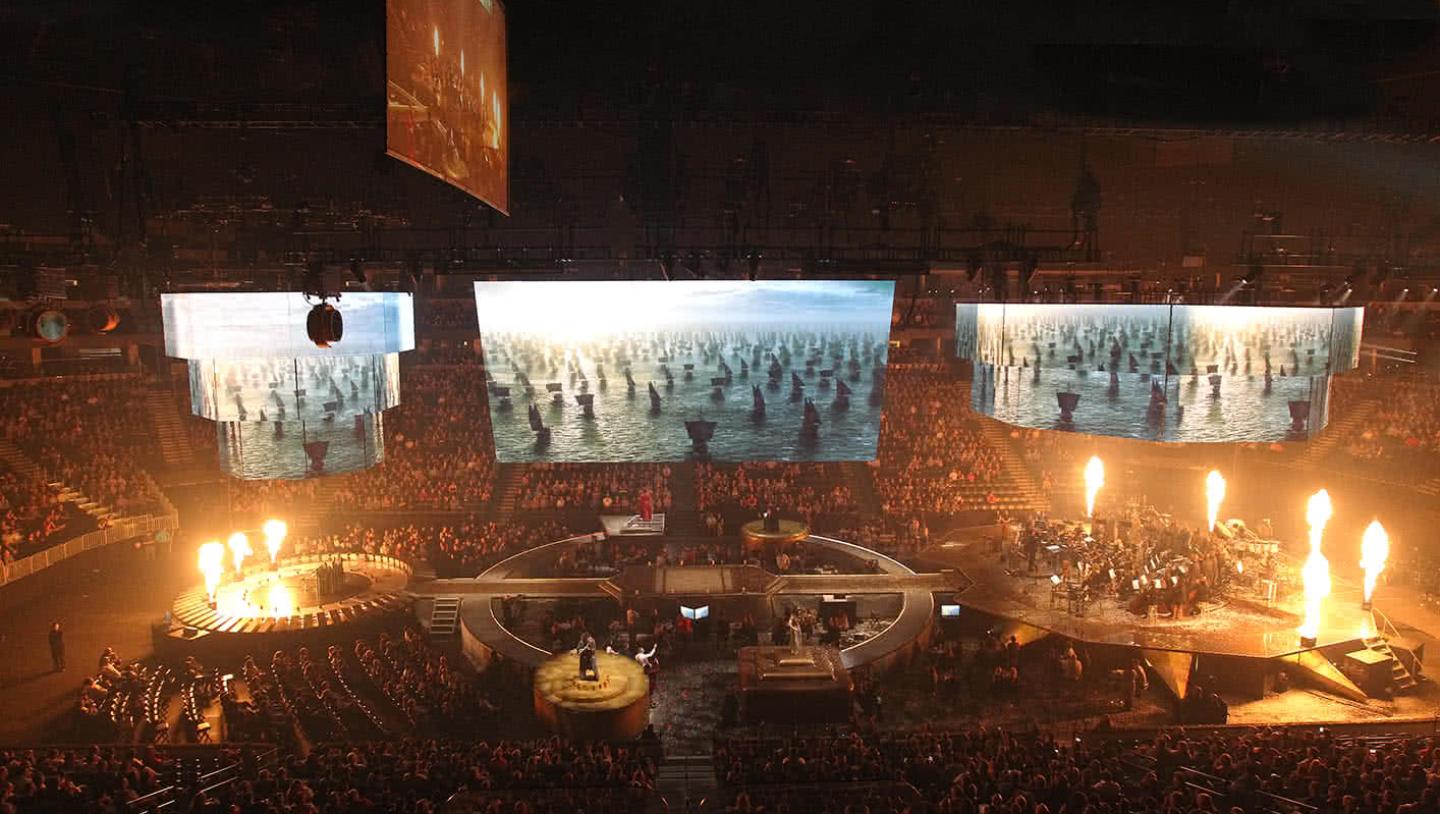 Orchestra performs on stage whilst LED displays shows videos game of thrones