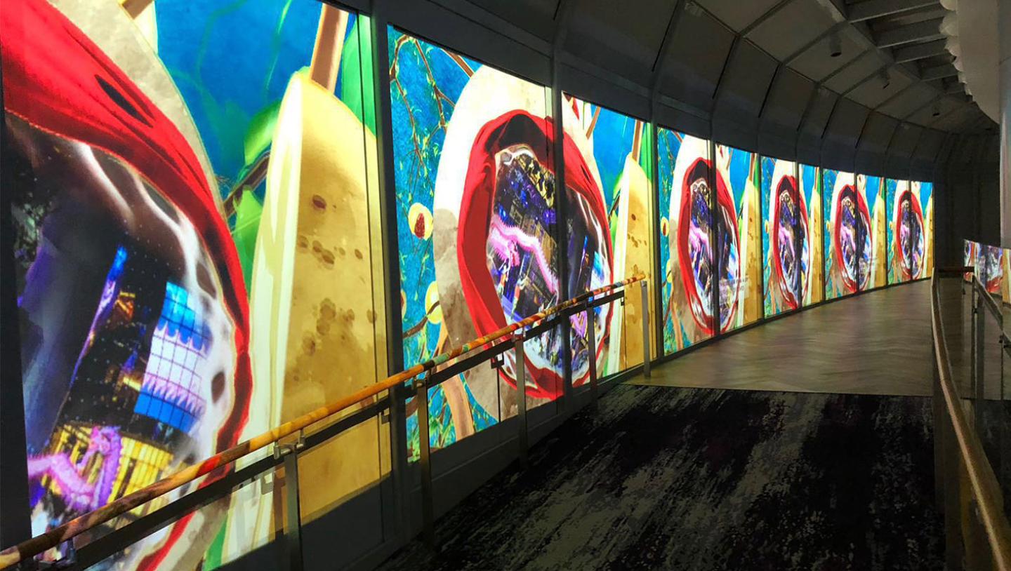 A series of multimedia screens along a walkway