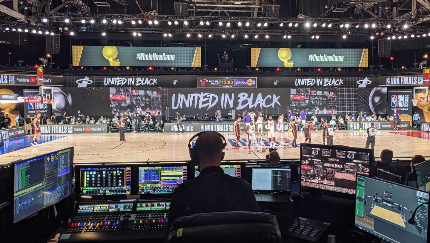 Backstage of man working on visual displays for basketball game