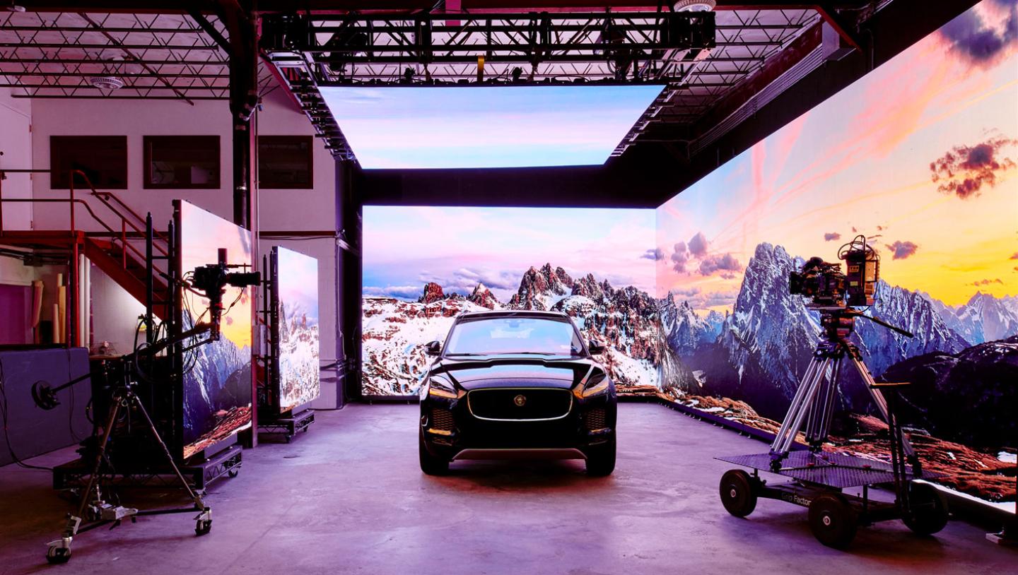 Car being shot in front of LED screen featuring mountainous background