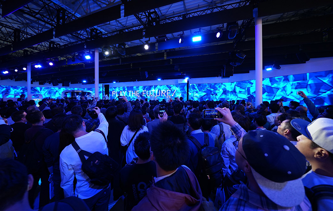Large crowd of people holding their cameras up as corporate presentation kicks off