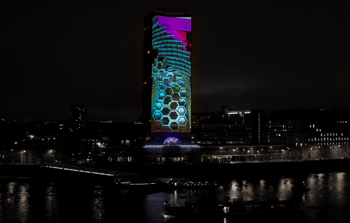 Millbank Tower in London lit up with blue and purple lighting